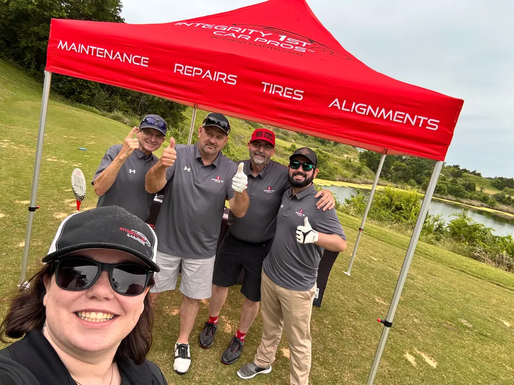Integrity 1st team members under a branded canopy at the company golf tournament