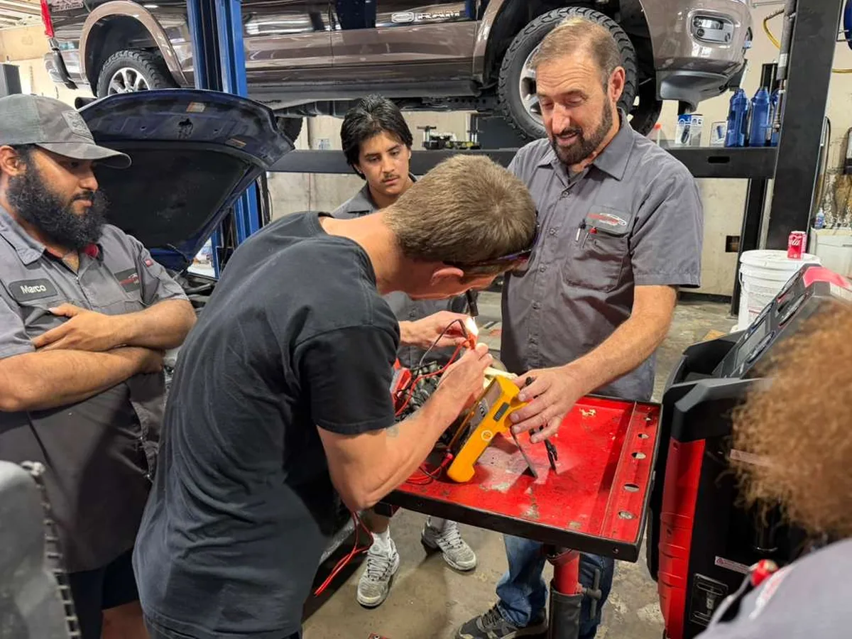 An instructor demonstrating an AC diagnostic tool to Integrity 1st technicians