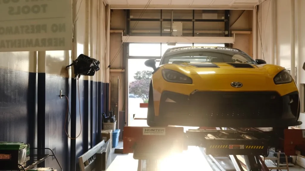 A vehicle raised on a lift inside the service bays at the Integrity 1st Car Pros shop on Davenport Rd in Dallas