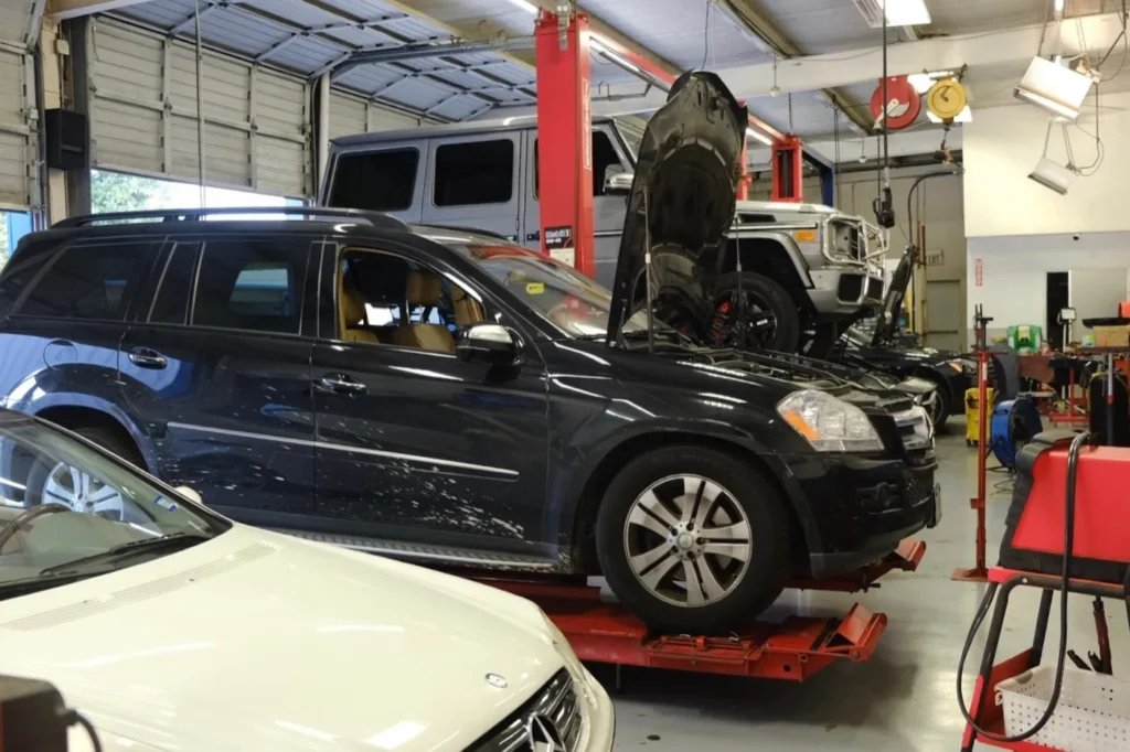 An SUV up on a lift with its wheels off in the service bays at the Davenport Road shop