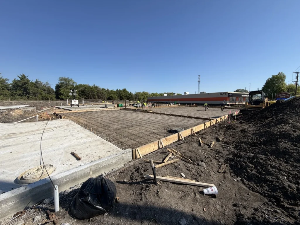 A poured concrete edge beside the reinforcing mat at the new Wylie site in October 2026