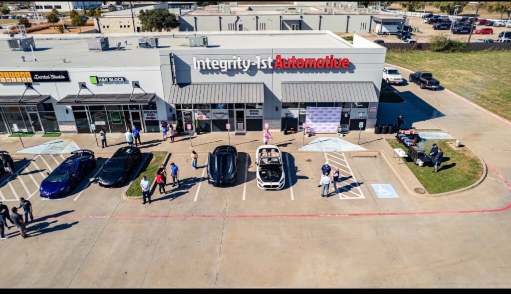 Aerial view of the Wylie shop during a community car show, cars lined up out front